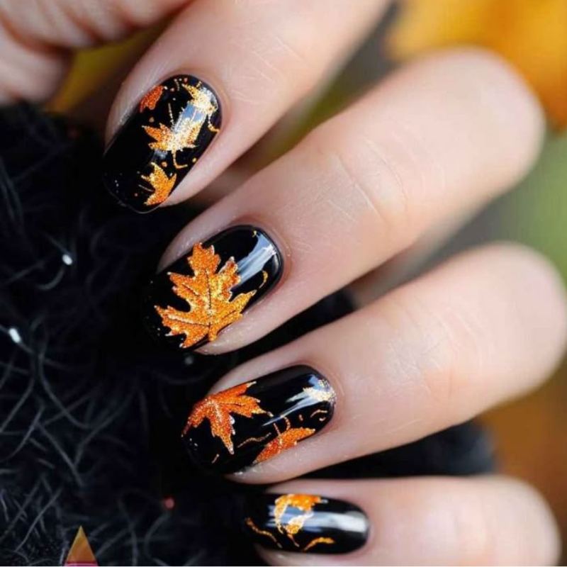 Orange and burgundy fall leaves on nude halloween nails