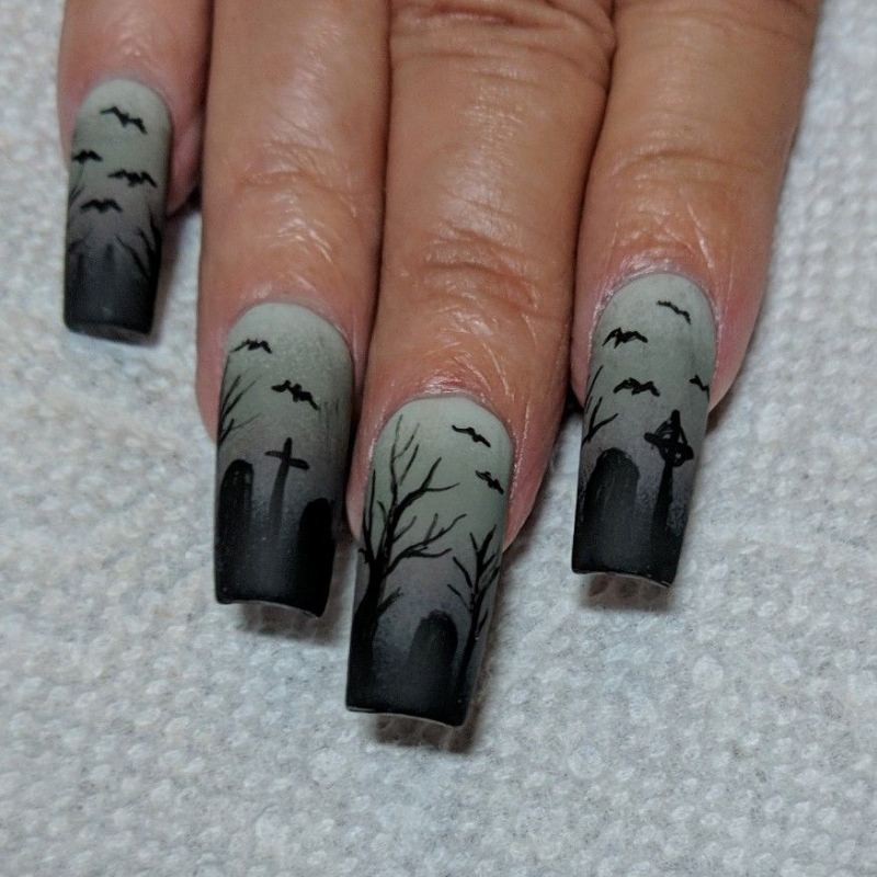 Spooky graveyard silhouette on purple halloween nails