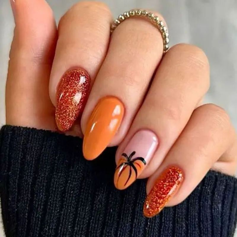Orange pumpkin nail art with green stem details