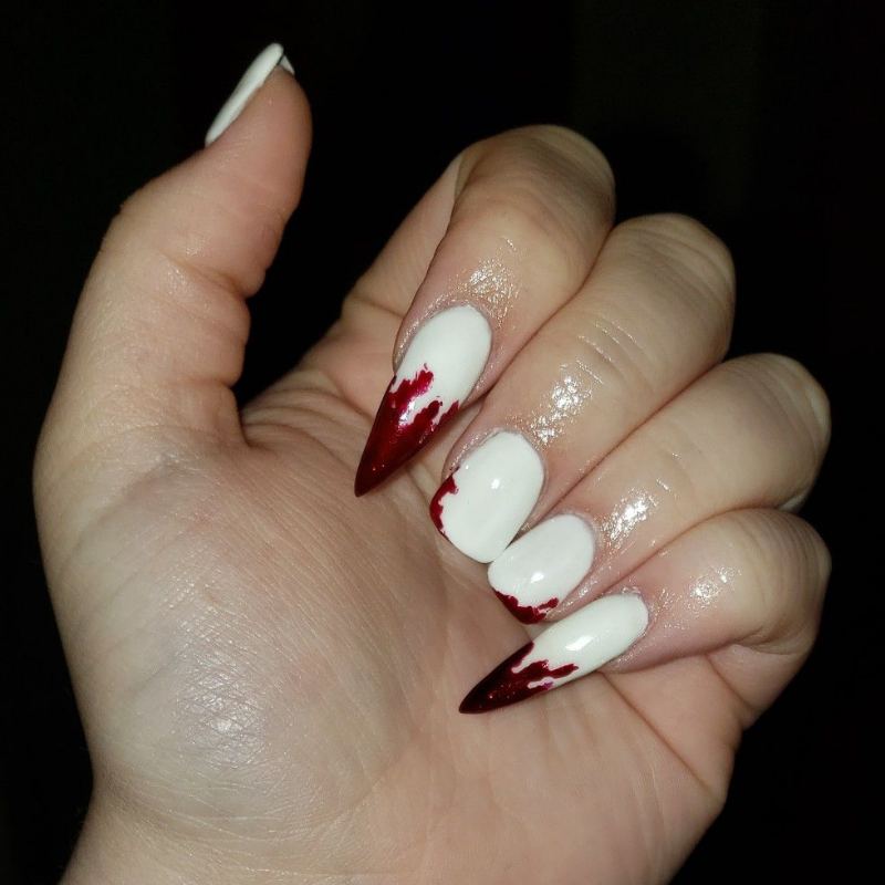 White vampire fang details on red halloween nails