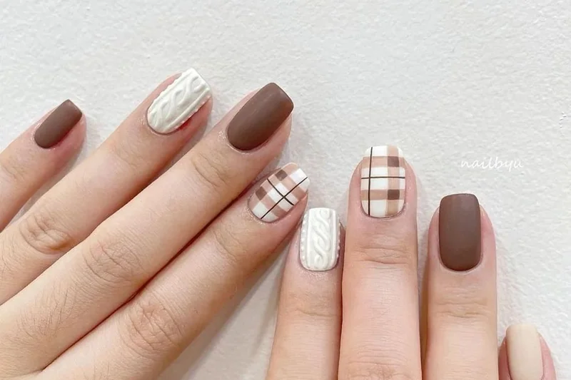 Winter 2025 striped sweater nail art featuring burgundy and cream horizontal knit texture pattern for cozy look